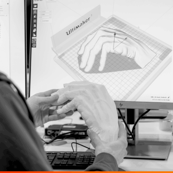 3D geprinte hand met een schets van de hand op beeldscherm